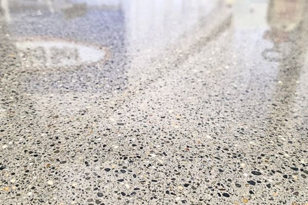 Reflective polished concrete floor with exposed aggregate in a commercial unit